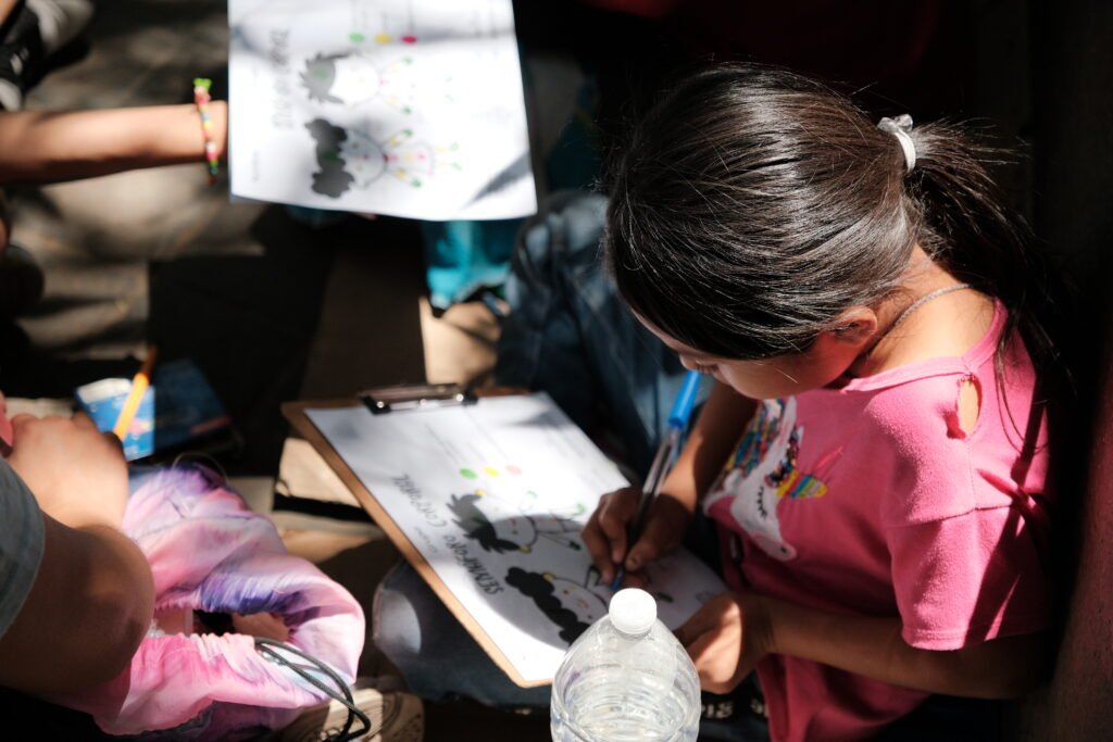 Girl completing a prevention workshop worksheet at a community outreach