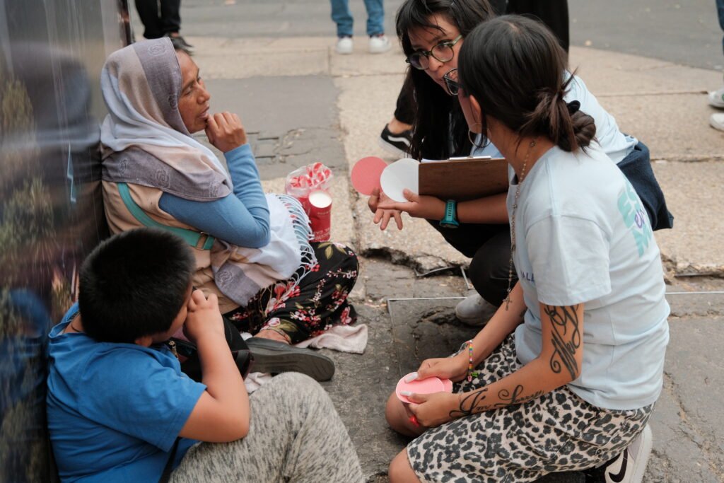 Volunteers talk with a mother and her son during street outreach